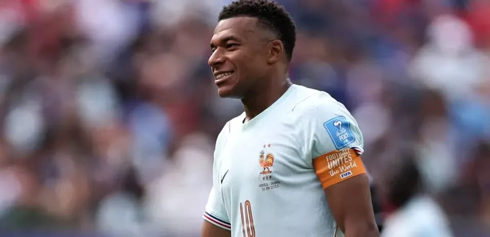 Jugador de Francia con camiseta clara sonriendo en el campo