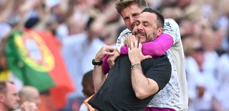 Dos entrenadores celebrando en el campo de juego