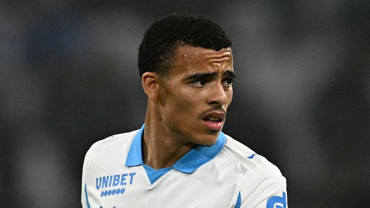 Jugador de fútbol con camiseta blanca y azul en el campo