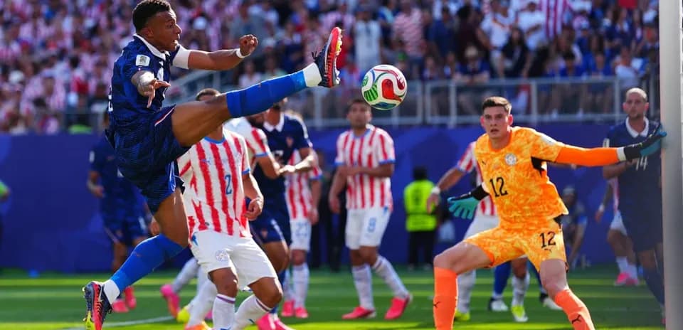 Jugador francés pateando el balón frente al portero