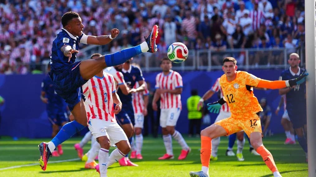 Jugador francés pateando el balón frente al portero