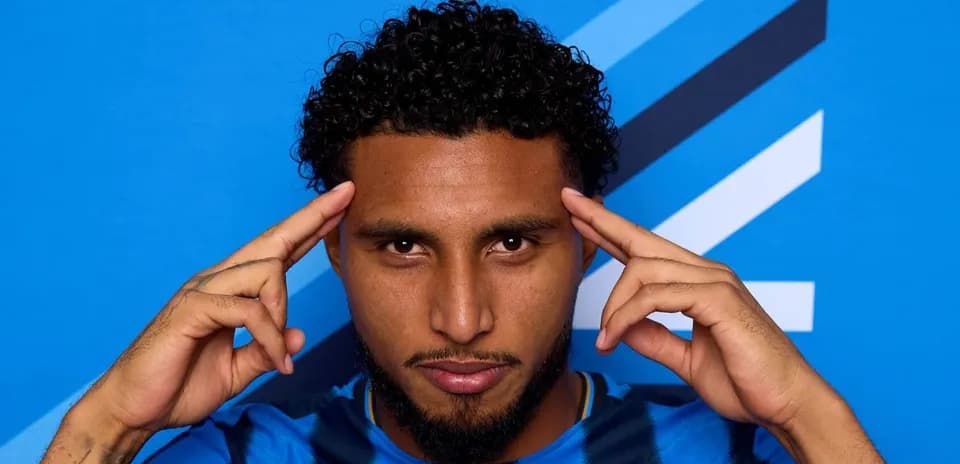 Jugador con camiseta azul posando frente fondo azul