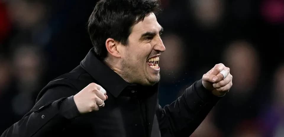 Entrenador celebrando con puños en alto durante el partido