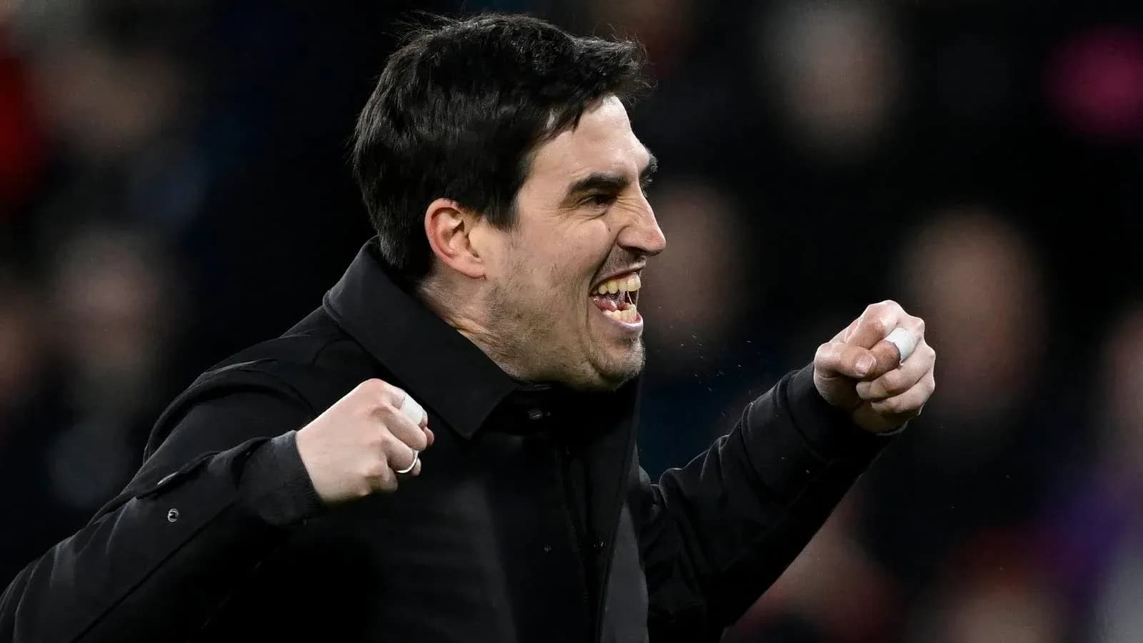 Entrenador celebrando con puños en alto durante el partido
