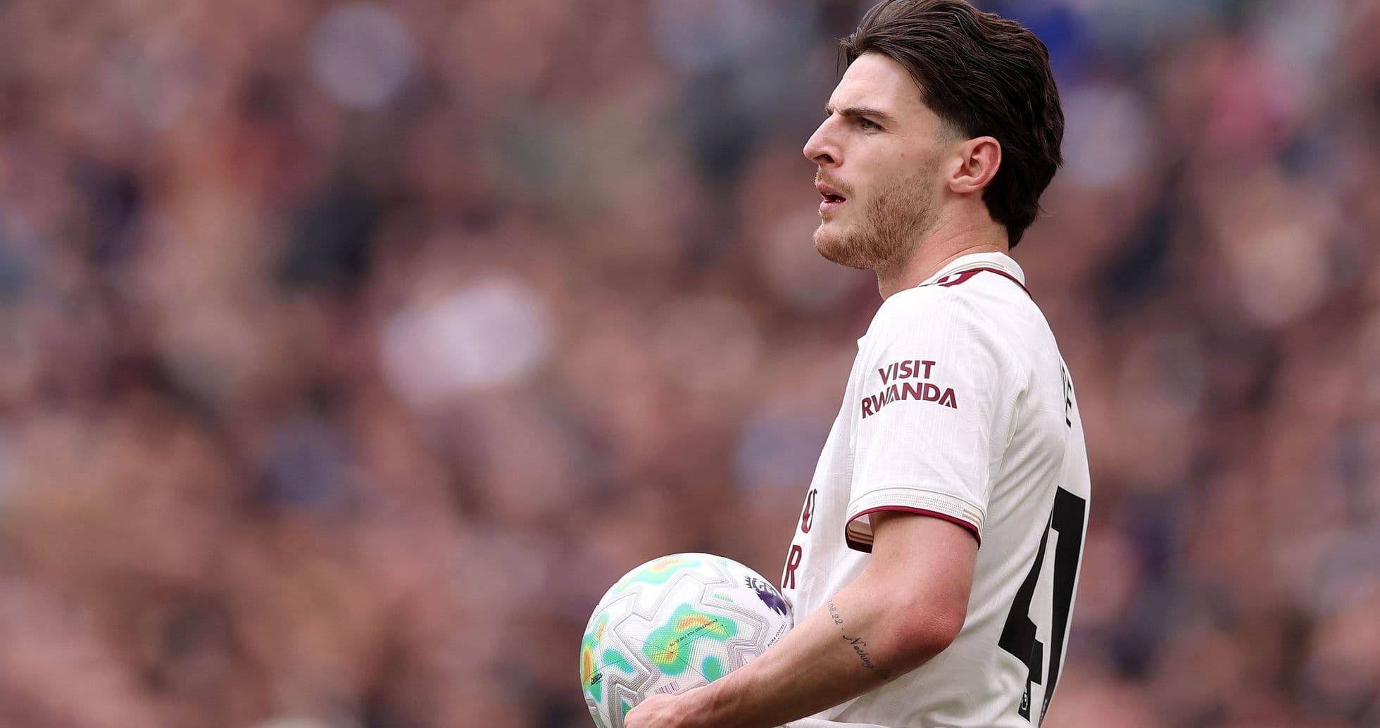 Jugador sosteniendo balón durante partido de fútbol