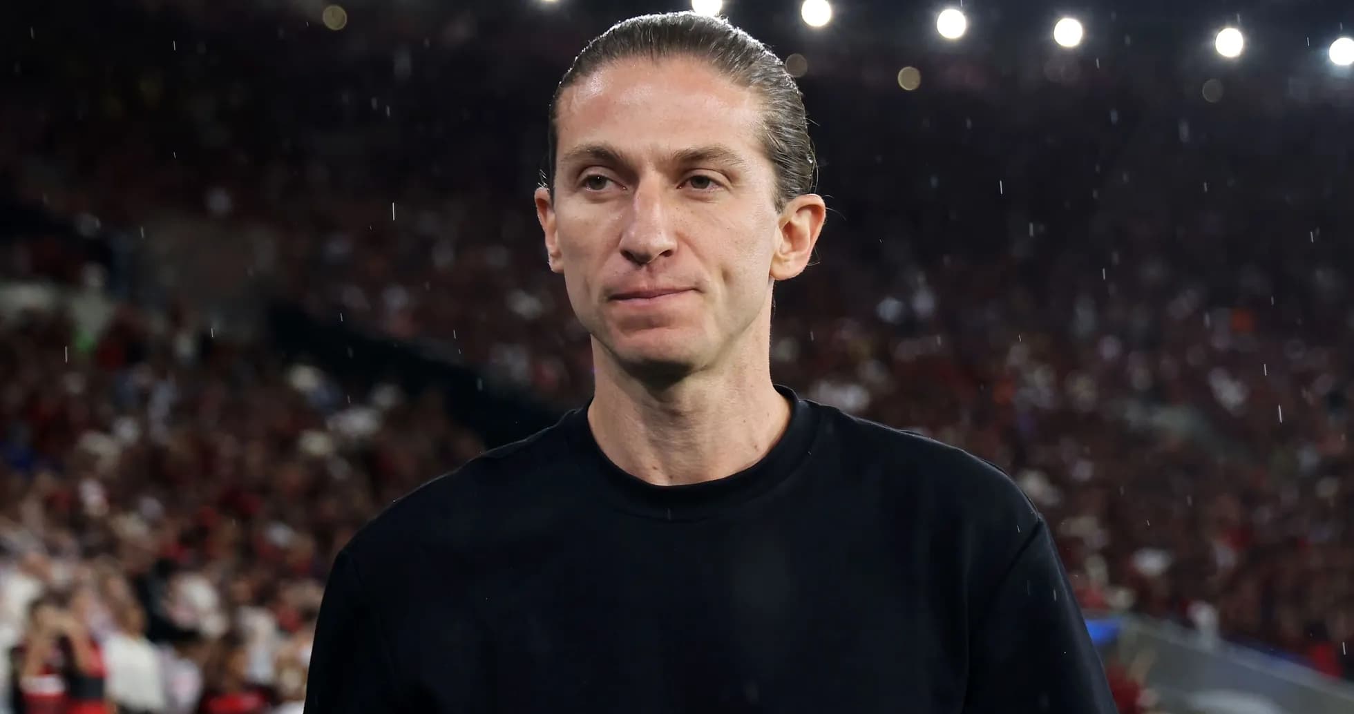 Entrenador en campo durante partido con lluvia