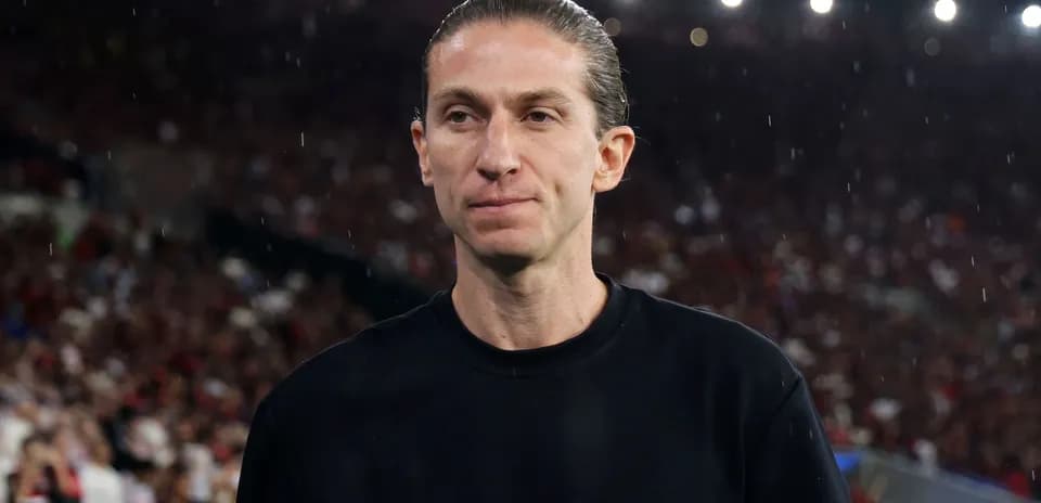 Entrenador en campo durante partido con lluvia