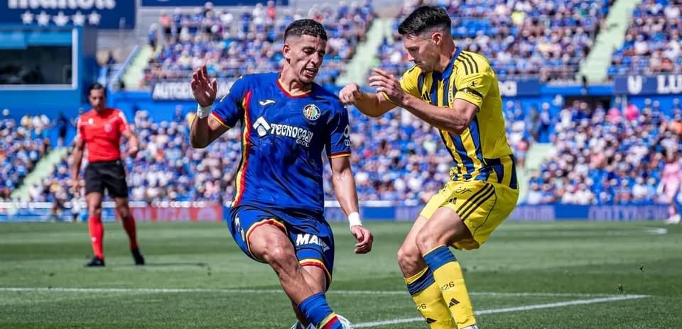 Jugador de Getafe enfrentándose a un jugador de Oviedo