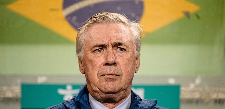 Entrenador en conferencia con bandera de Brasil de fondo