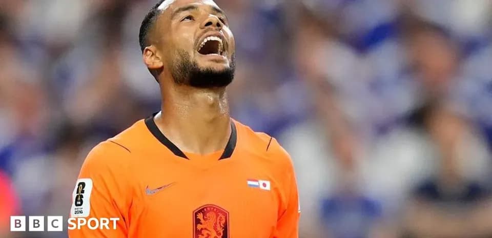 Jugador de fútbol en uniforme naranja mirando hacia arriba