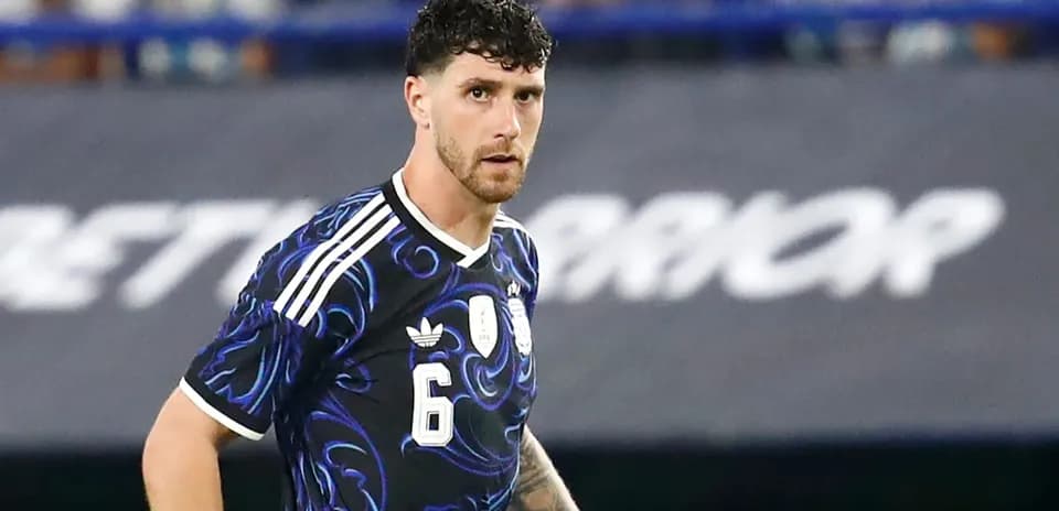 Jugador de fútbol con camiseta negra y detalles azules