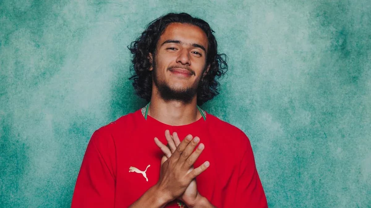 Jugador posando con camiseta roja y manos juntas