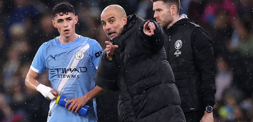 Entrenador hablando con jugador en el banquillo