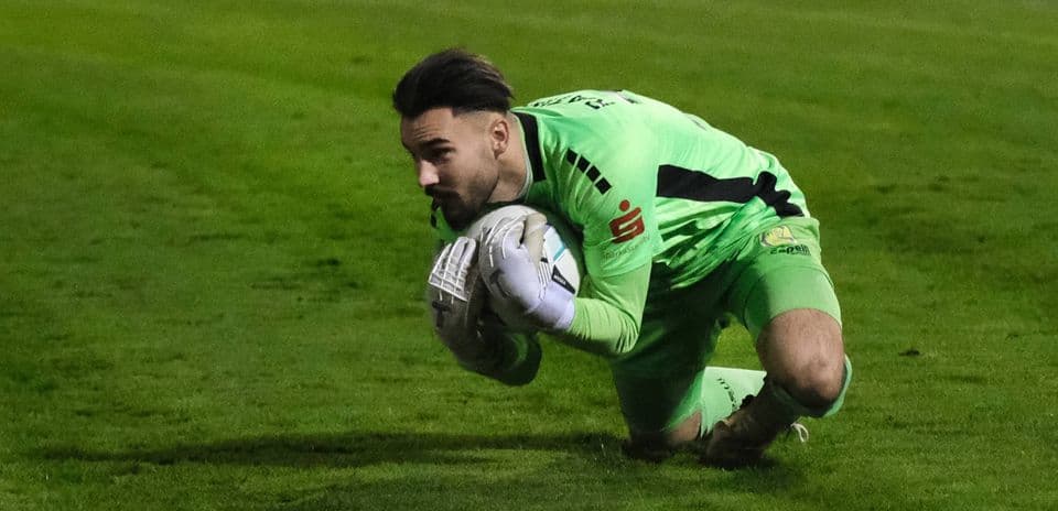 Portero atrapando el balón en el partido