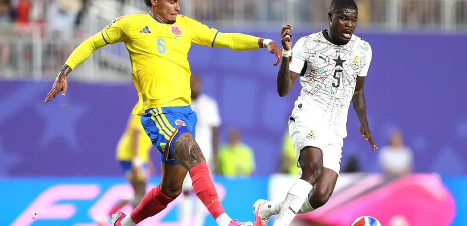 Jugador colombiano persigue a rival ghanés