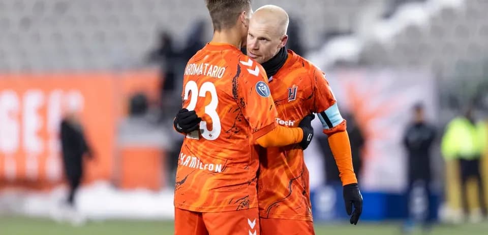 Dos jugadores abrazándose en el campo de fútbol