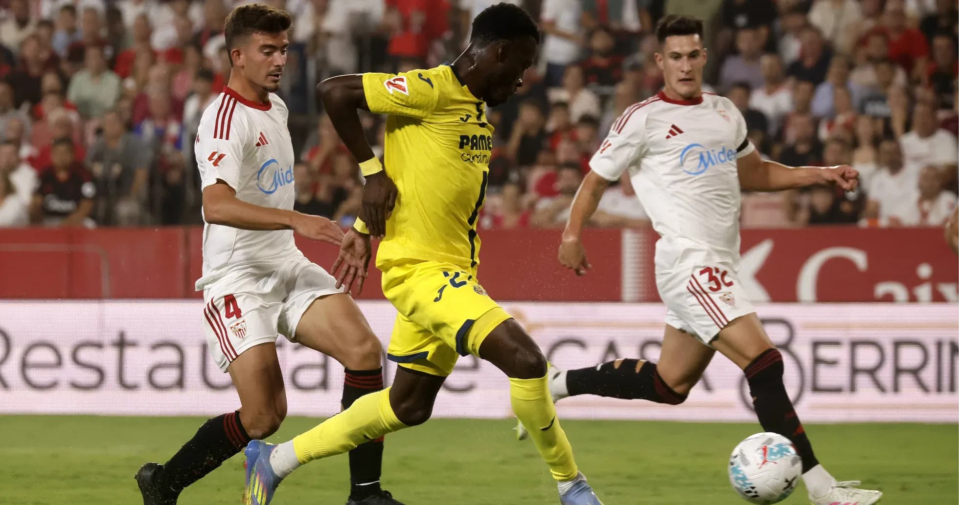 Jugador de Villarreal driblando a defensores de Sevilla