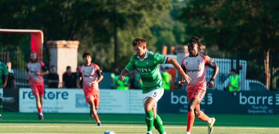 Jugador con balón durante partido de fútbol