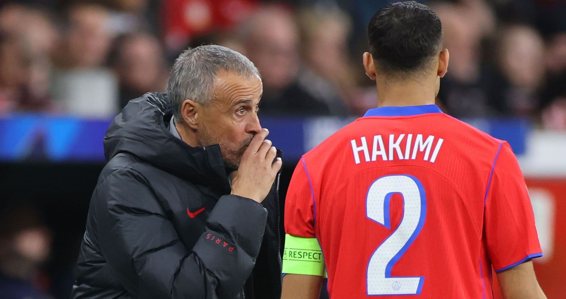 Entrenador hablando con Hakimi en el banquillo