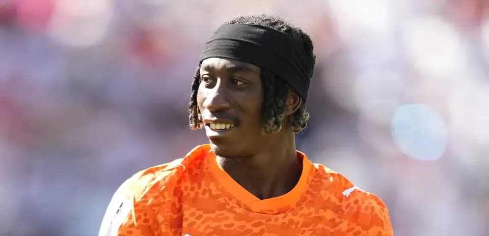 Jugador con camiseta naranja sonriendo durante el partido