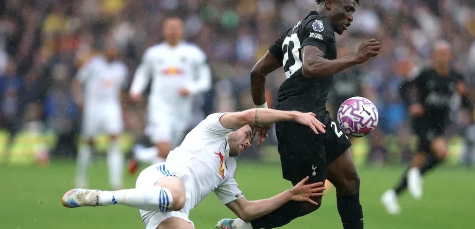 Jugador de Tottenham corriendo mientras es tackleado