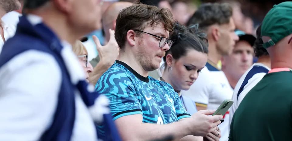 Espectadores en el estadio usando sus teléfonos móviles