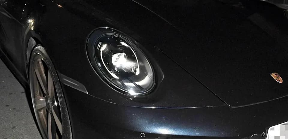 Dos personas dentro de un Porsche en la calle