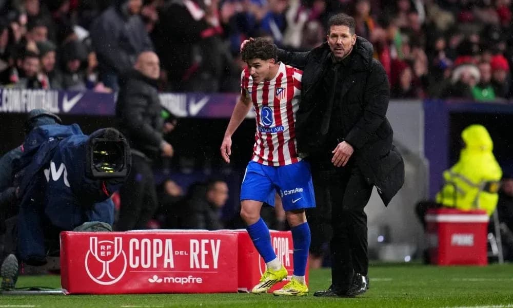 Entrenador ayudando a jugador del Atlético de Madrid