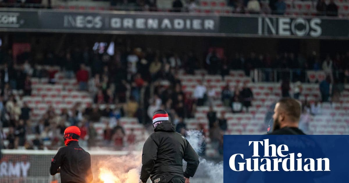 Aficionados en el estadio con bengalas encendidas