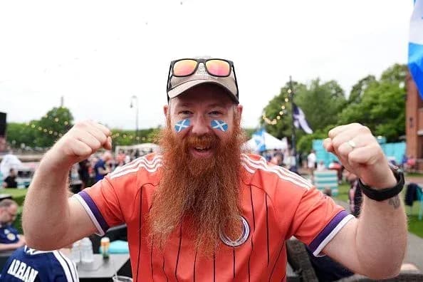 A fan celebrating with face paint and cheering