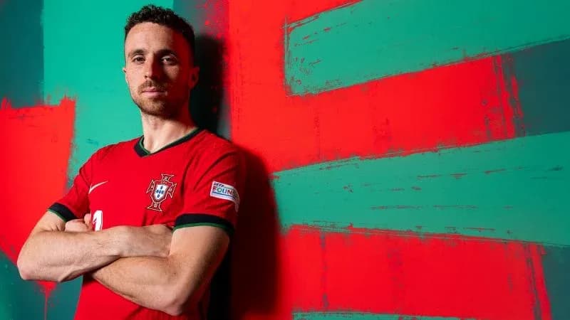 Jugador posando con camiseta de Portugal en fondo rojo