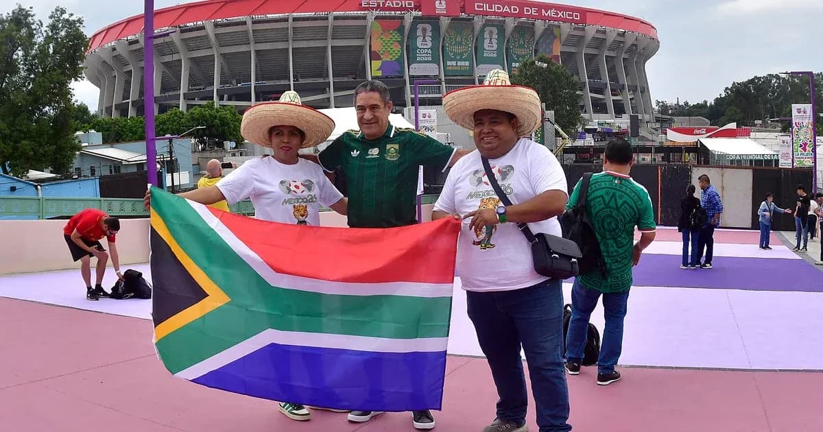Tres aficionados con bandera de Sudáfrica en estadio