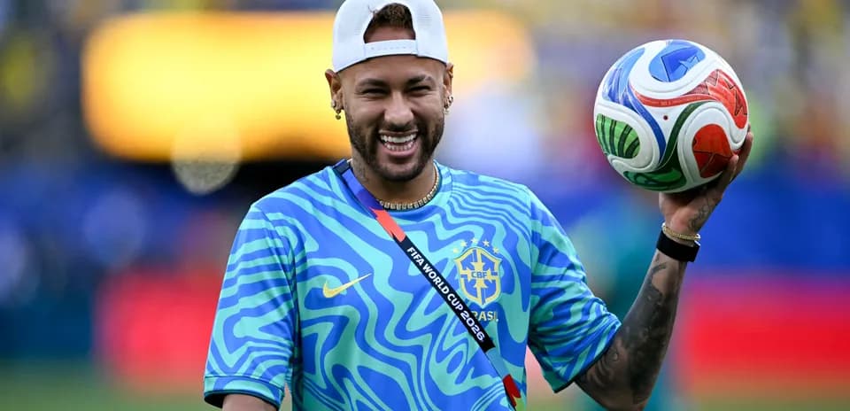 Neymar sosteniendo un balón en el campo de juego