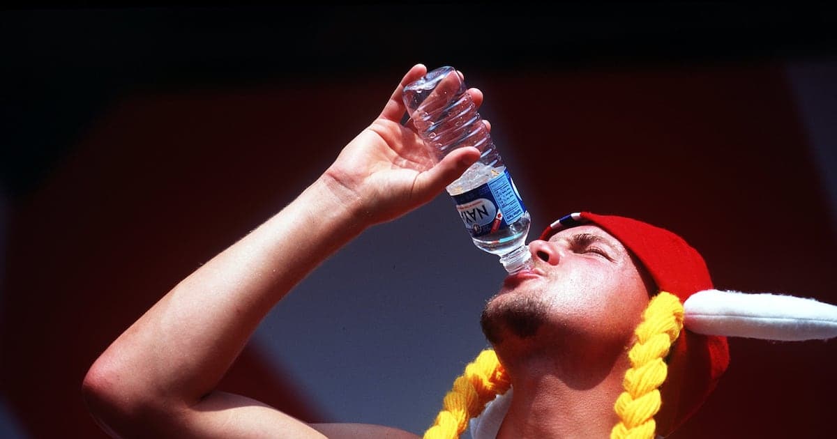 Hombre bebiendo agua de botella en evento deportivo