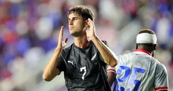 Jugador con camiseta negra aplaudiendo en el campo