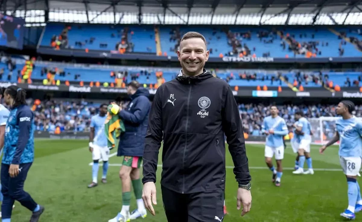 Entrenador sonriendo al salir del campo tras el partido