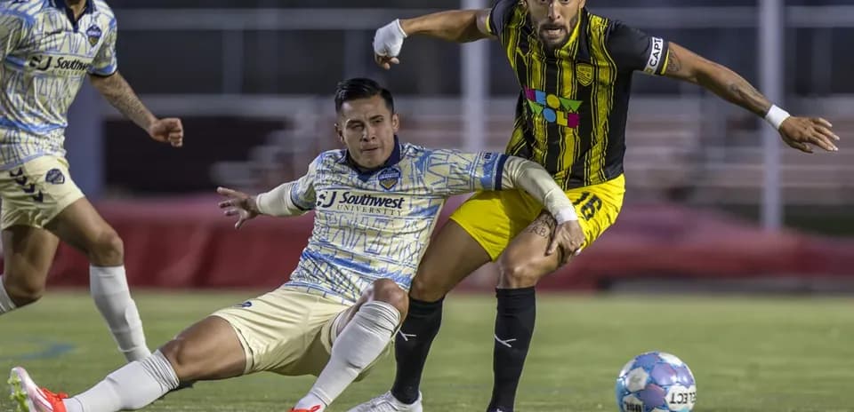 Dos jugadores compitiendo por el balón en partido