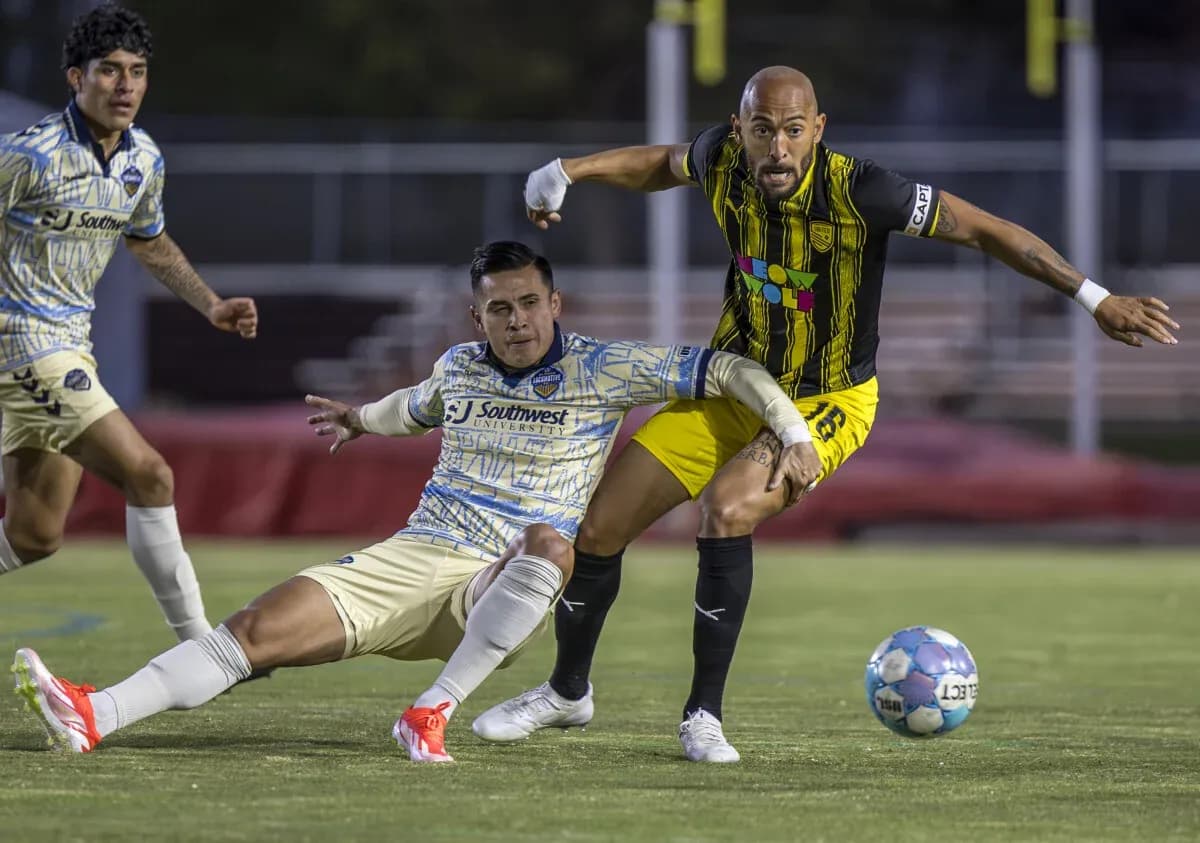 Dos jugadores compitiendo por el balón en partido