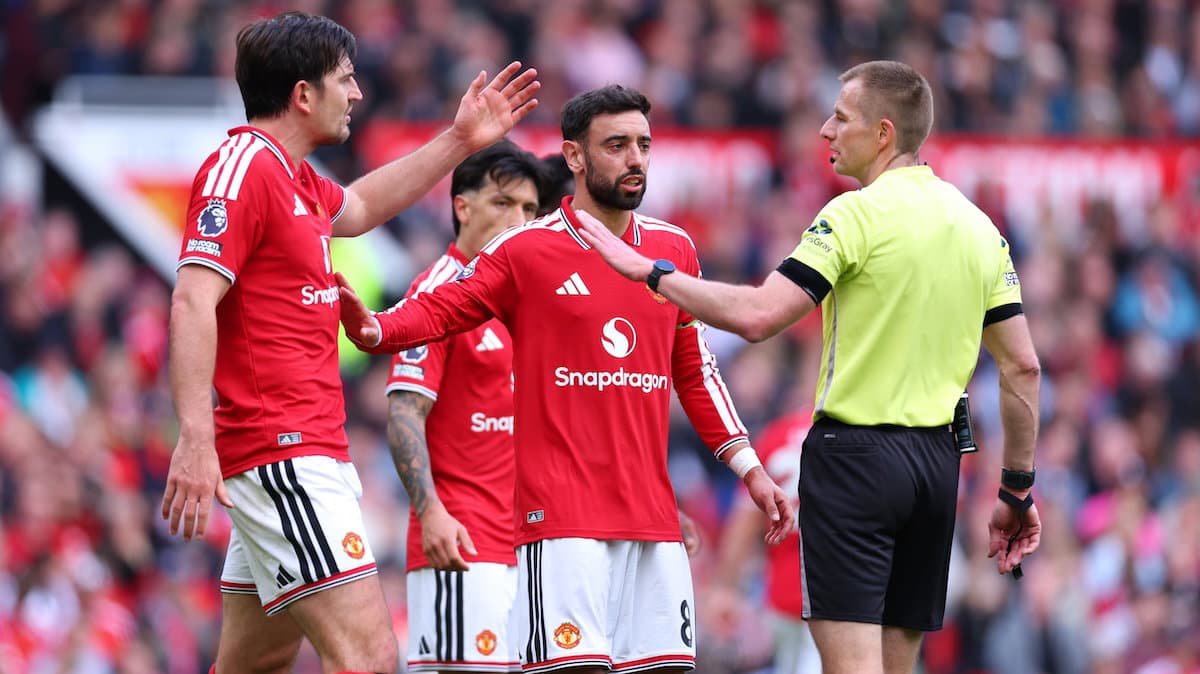 Jugadores de Manchester United discutiendo con el árbitro