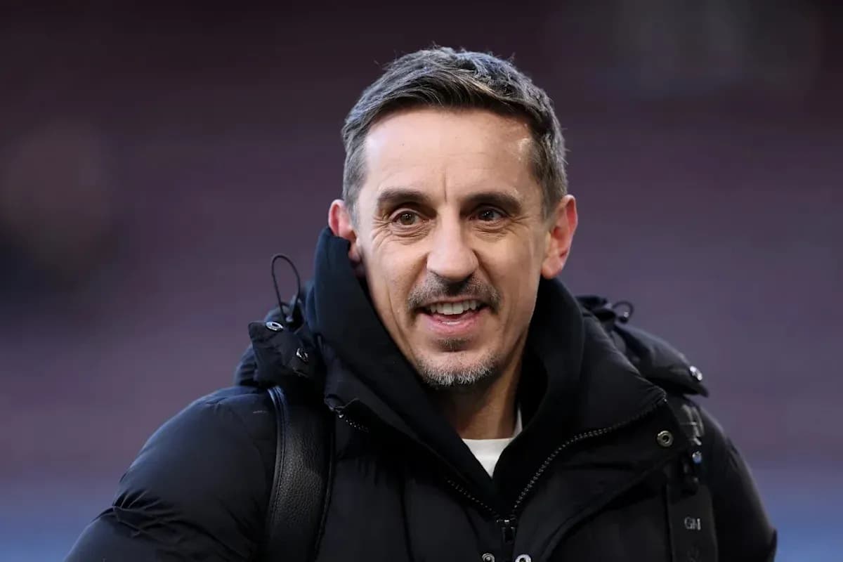 Hombre sonriendo con abrigo en un estadio