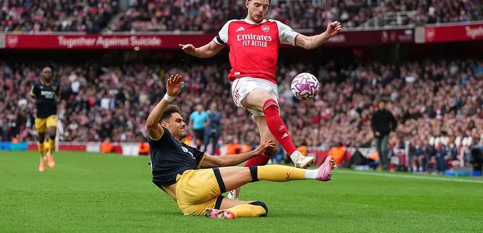 Jugador de Arsenal esquivando una entrada de West Ham