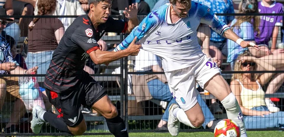 Jugador de Vancouver FC desafiando a rival de Pacific FC