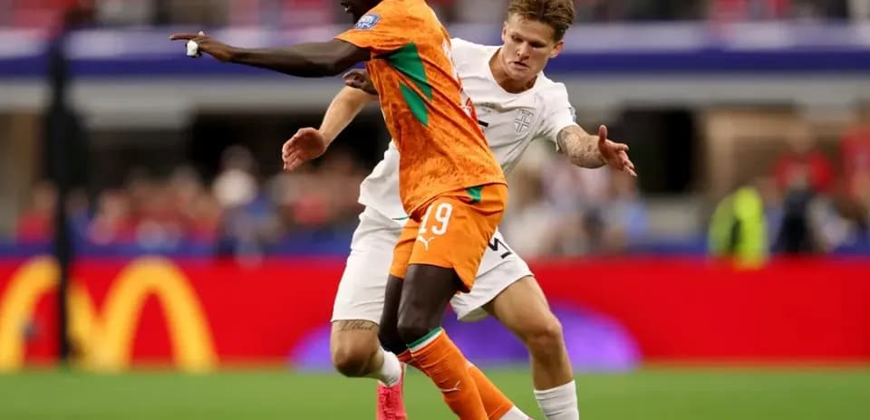 Jugador de Costa de Marfil driblando a oponente inglés