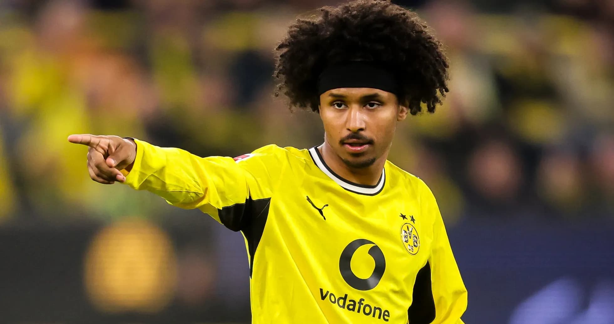 Jugador señalando durante partido con uniforme amarillo
