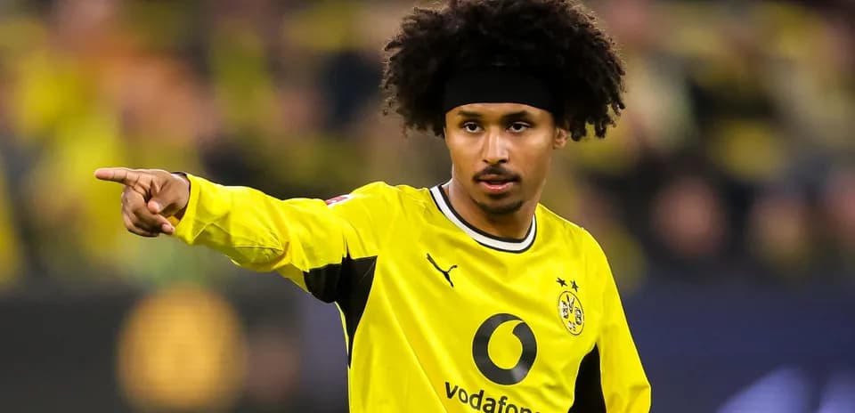 Jugador señalando durante partido con uniforme amarillo