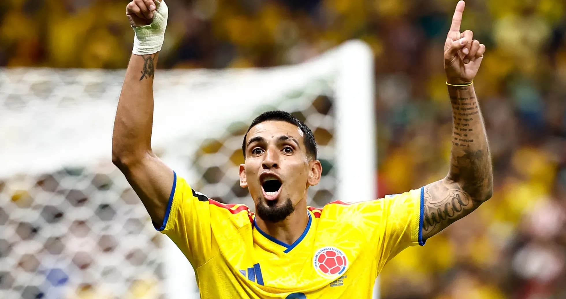 Jugador colombiano celebrando con los brazos en alto