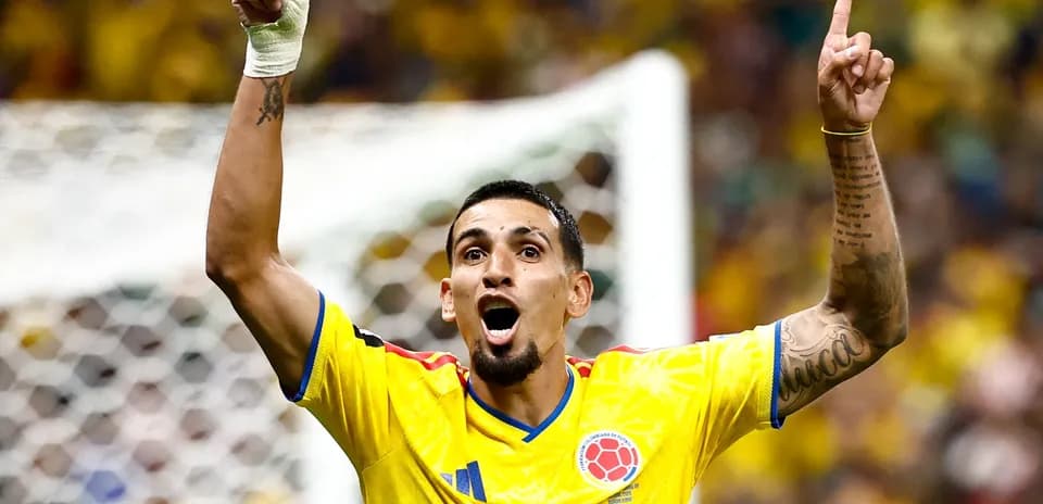 Jugador colombiano celebrando con los brazos en alto