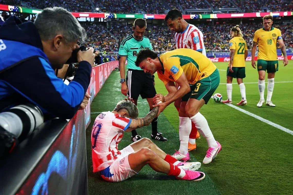 Jugador caído siendo atendido por rival y árbitro