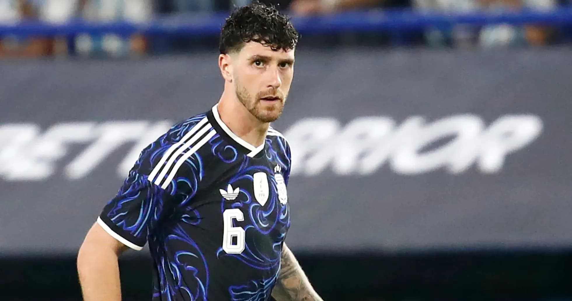 Jugador de fútbol con camiseta negra y detalles azules Jugador de fútbol con camiseta negra y detalles azules
