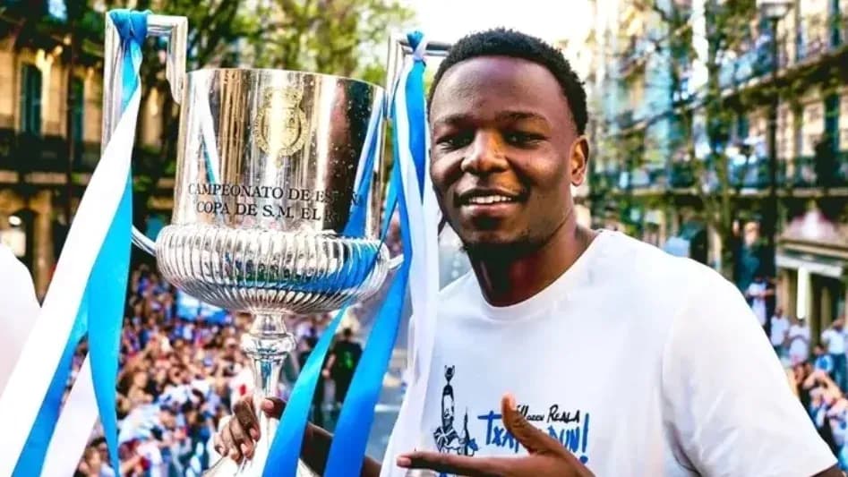 Jugador sosteniendo trofeo en celebración pública Jugador sosteniendo trofeo en celebración pública